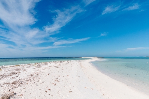 Sandy flat, desert Island with turquoise ocean and blue sky