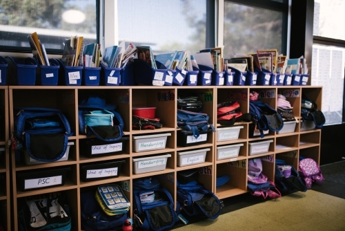 School bags and supplies on shelves in a classroom