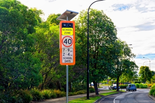 School zone warning sign with 40 km signal lights on the side of the road