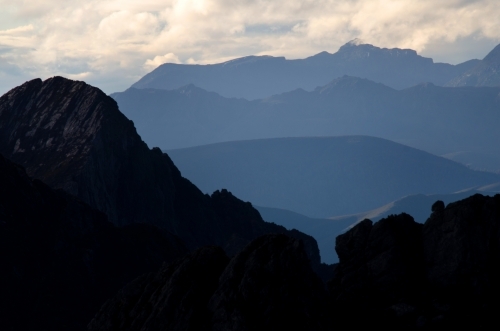 Silhouette of a mountain at the front of a mountain range
