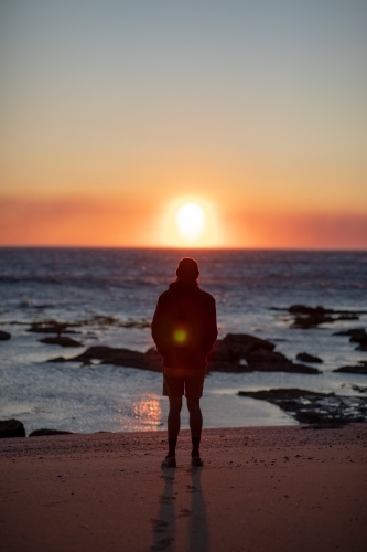 Silhouette of Man on Beach Looking at Sunrise