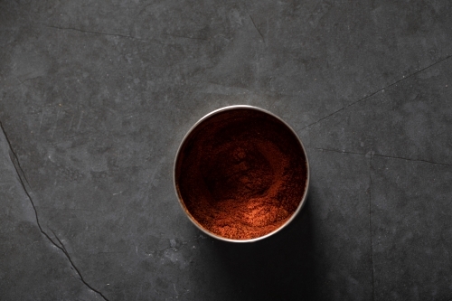Spice tin of paprika on dark marble background