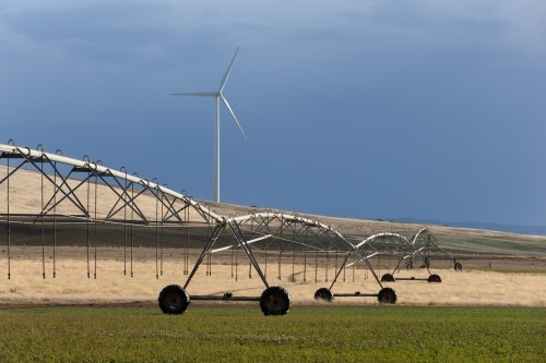 Sprayer on paddock with crops with wind turbine in background