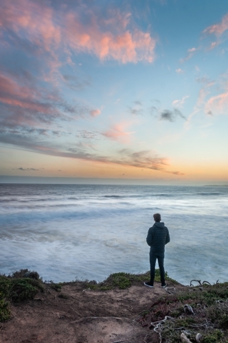Man Standing on a Great Ocean Road Cliff at Sunset