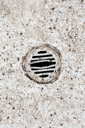 Stone floor with water drain in public toilet