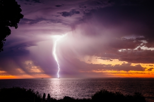Sunset lightning bolt and stormy sky over the ocean