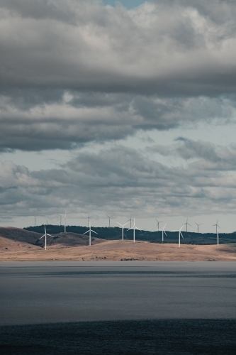 Sustainable energy wind turbines on the rolling hills behind Lake George.