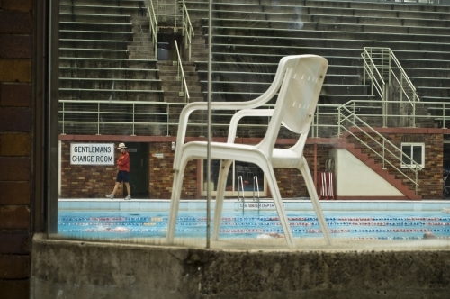 Swimming pool and chair through window