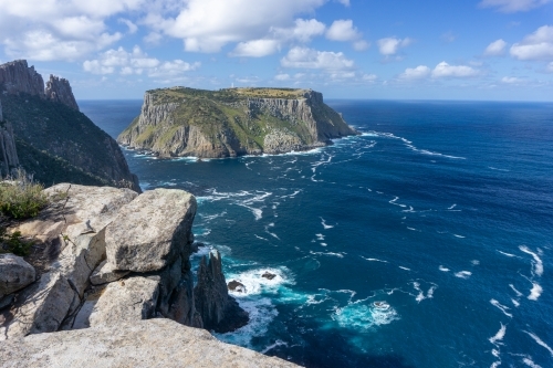 Tasman Island on a sunny day with waves and foam on the ocean
