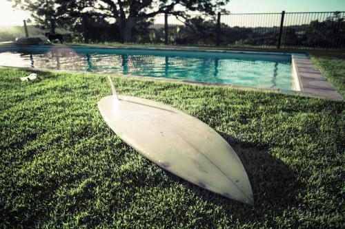 The surfboard with lens flair by the pool
