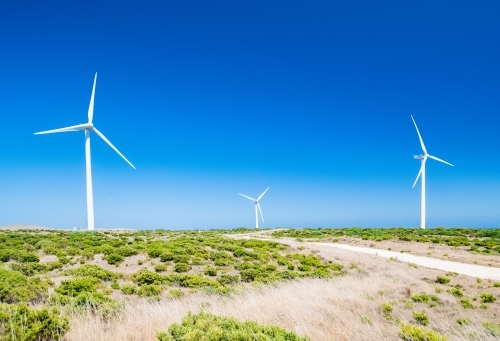 Three Wind turbines against the blue sky at a wind farm.