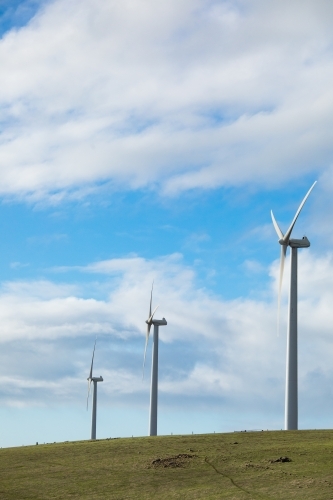 Three wind turbines on a bare grassy hill in the Fleurieu Peninsula.