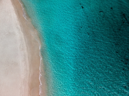 top shot of a white sand beach on a sunny day