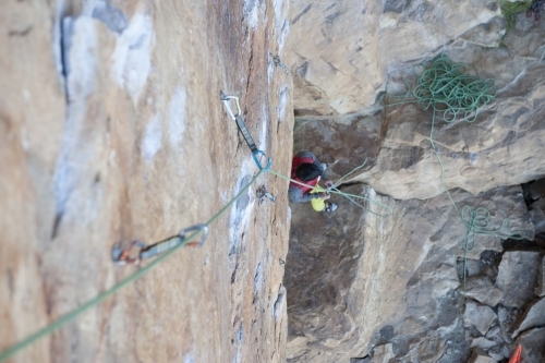 Traditional rock climbing protection on wall with climber