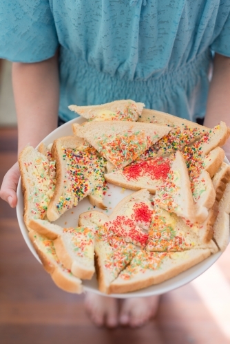 Tween girl holding fairy bread on a plate