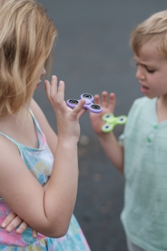 Two children playing with fidget spinner toys