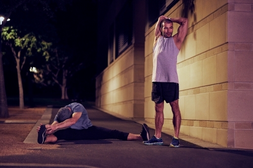 Two men fitness training in urban city at night