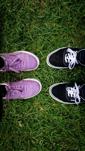 Two Pairs of Shoes Standing Together in Green Grass.