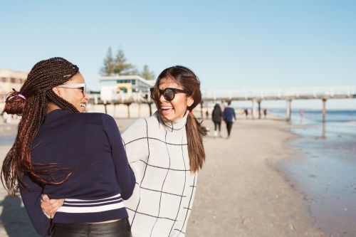 Two young women laughing on a beach