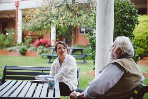 University teachers having a discussion at a bench in the garden
