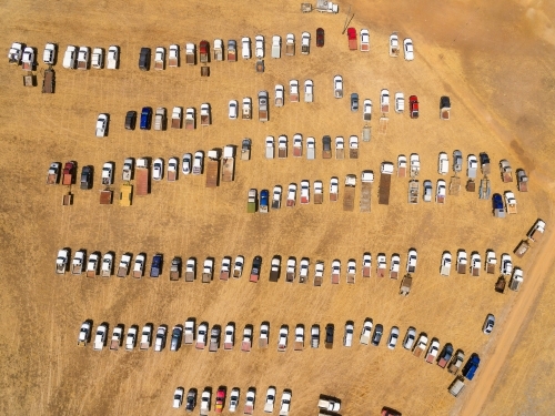 vehicles lined up and parked at a rural event