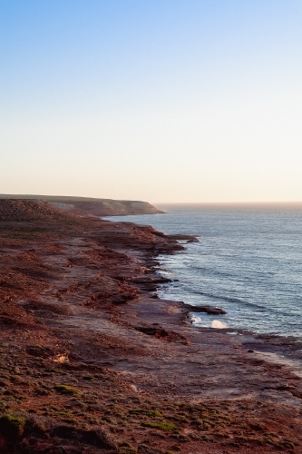 View along coastal rocky cliffs at sunset