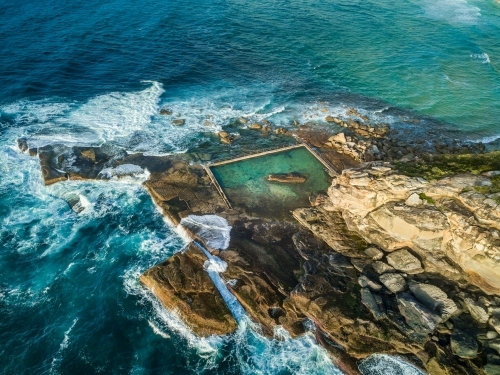 Views of the rockpool as it sits nestled at the bottom of the cliffs surrounded by ocean