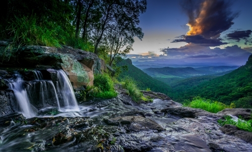 Waterfall overlooking valley of green bushland
