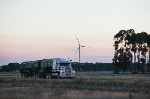 Wind turbine in the countryside on dusk with Semi Trailer transport foreground details
