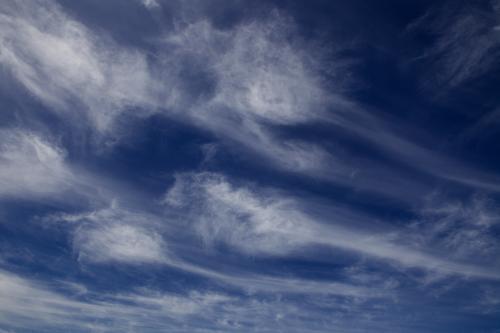 Wispy white clouds against a dark blue sky