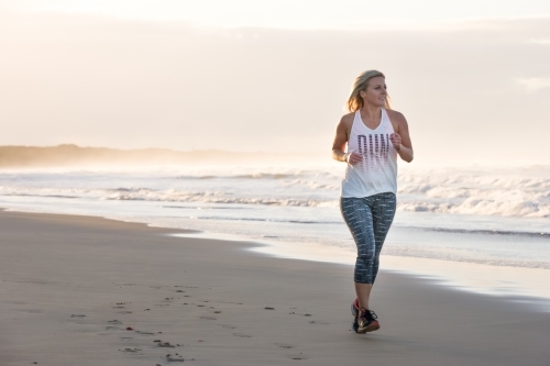 woman running on a beach in the early morning