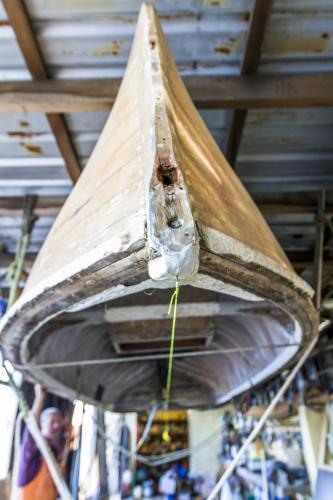 Wooden dinghy being restored upside down.