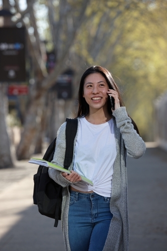 Young Asian female university student on mobile phone