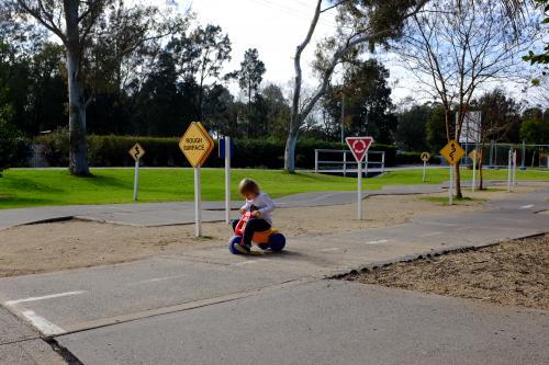 Young Boy riding bike around children's playground