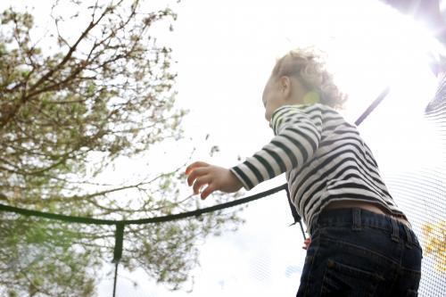Young child jumping on trampoline