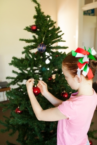 Young girl decorating a Christmas tree