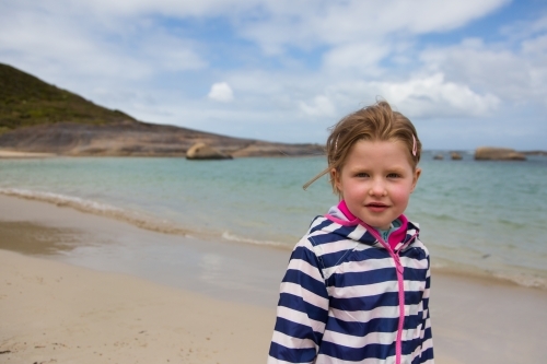 young girl in a raincoat at a beach in Spring