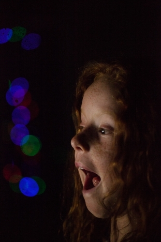 Young girl in low light with coloured lights
