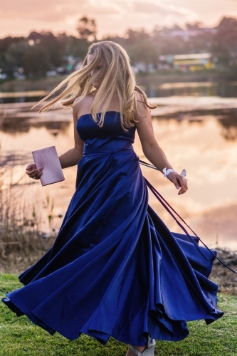 young woman spinning in formal dress in the afternoon light