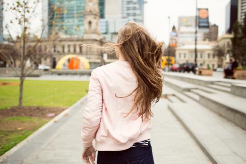 Young woman walking away in the city