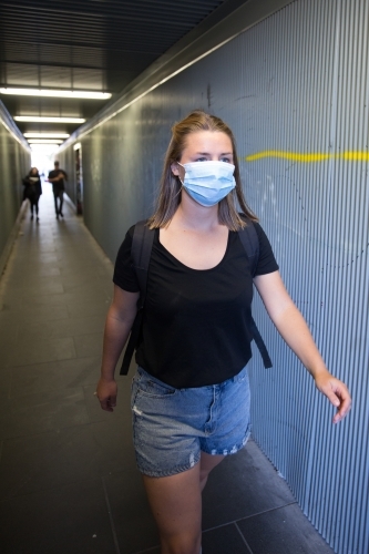 Young Woman with Face Mask Walking Through City Tunnel