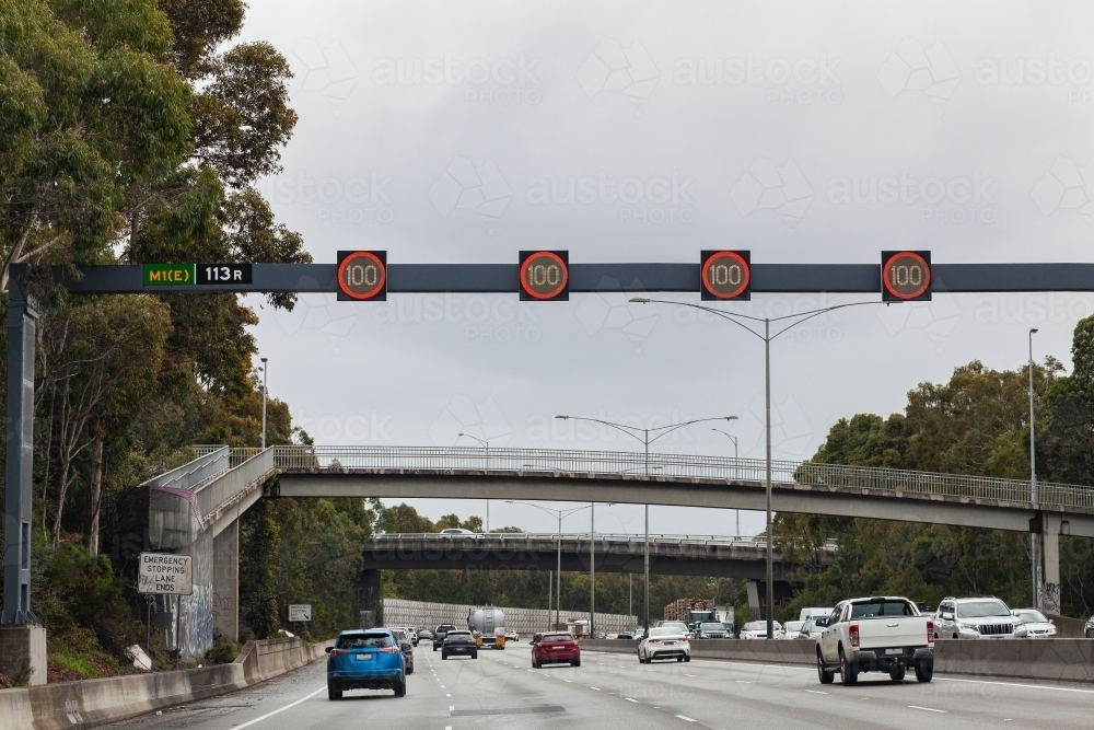 100 speed limit signs above busy multi lane road in city - Australian Stock Image