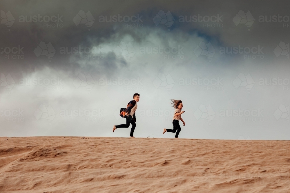 2 Boys running on Sand dune - Australian Stock Image