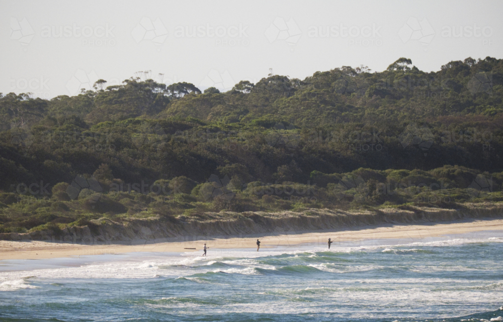 3 people beach fishing on a remote beach late afternoon light - Australian Stock Image