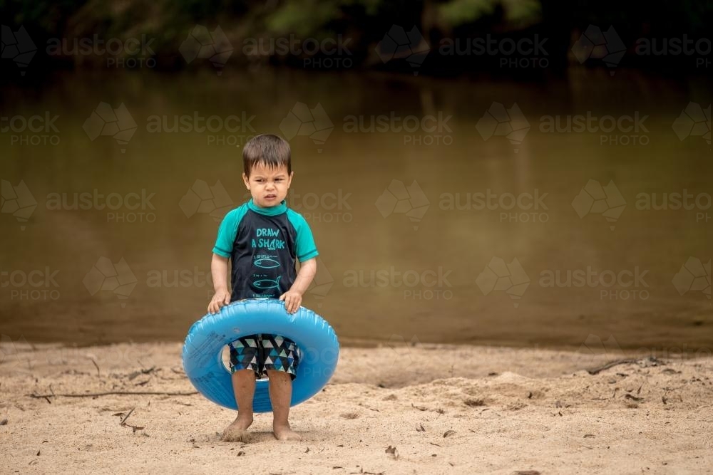 3 year old mixed race boy swims and plays in a river - Australian Stock Image