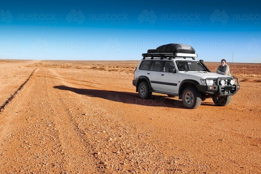 4 wheel drive vehicle alone on desert raod - Australian Stock Image