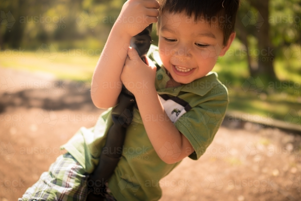 4 year old mixed race boy plays on a flying fox - Australian Stock Image