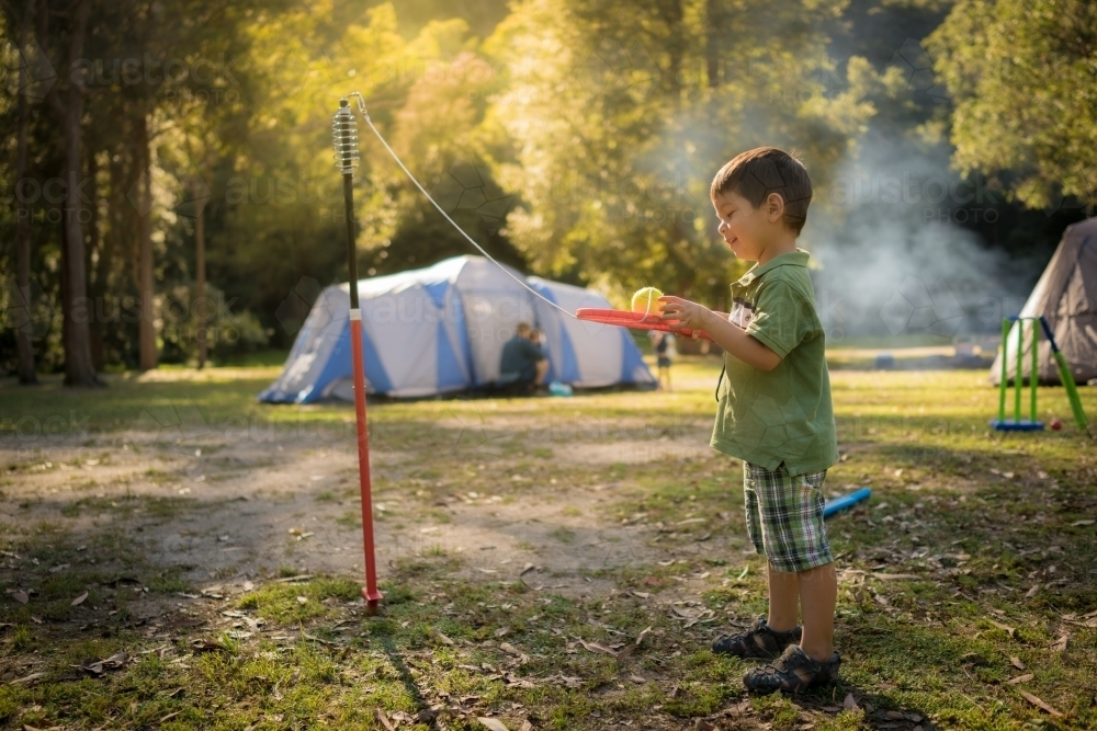 4 year old mixed race boy plays totem tennis on a camping trip - Australian Stock Image