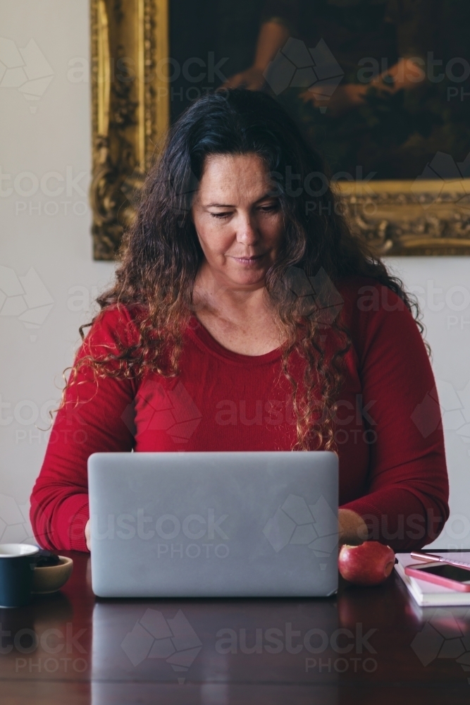 40 something woman working from home on laptop - Australian Stock Image