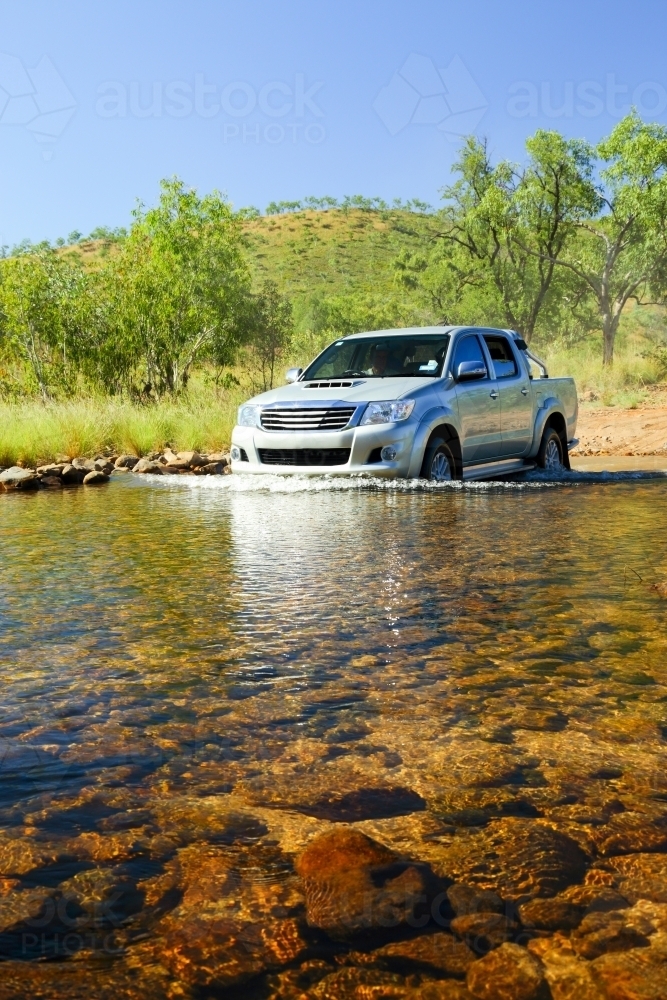 4WD crossing a placid creek - Australian Stock Image